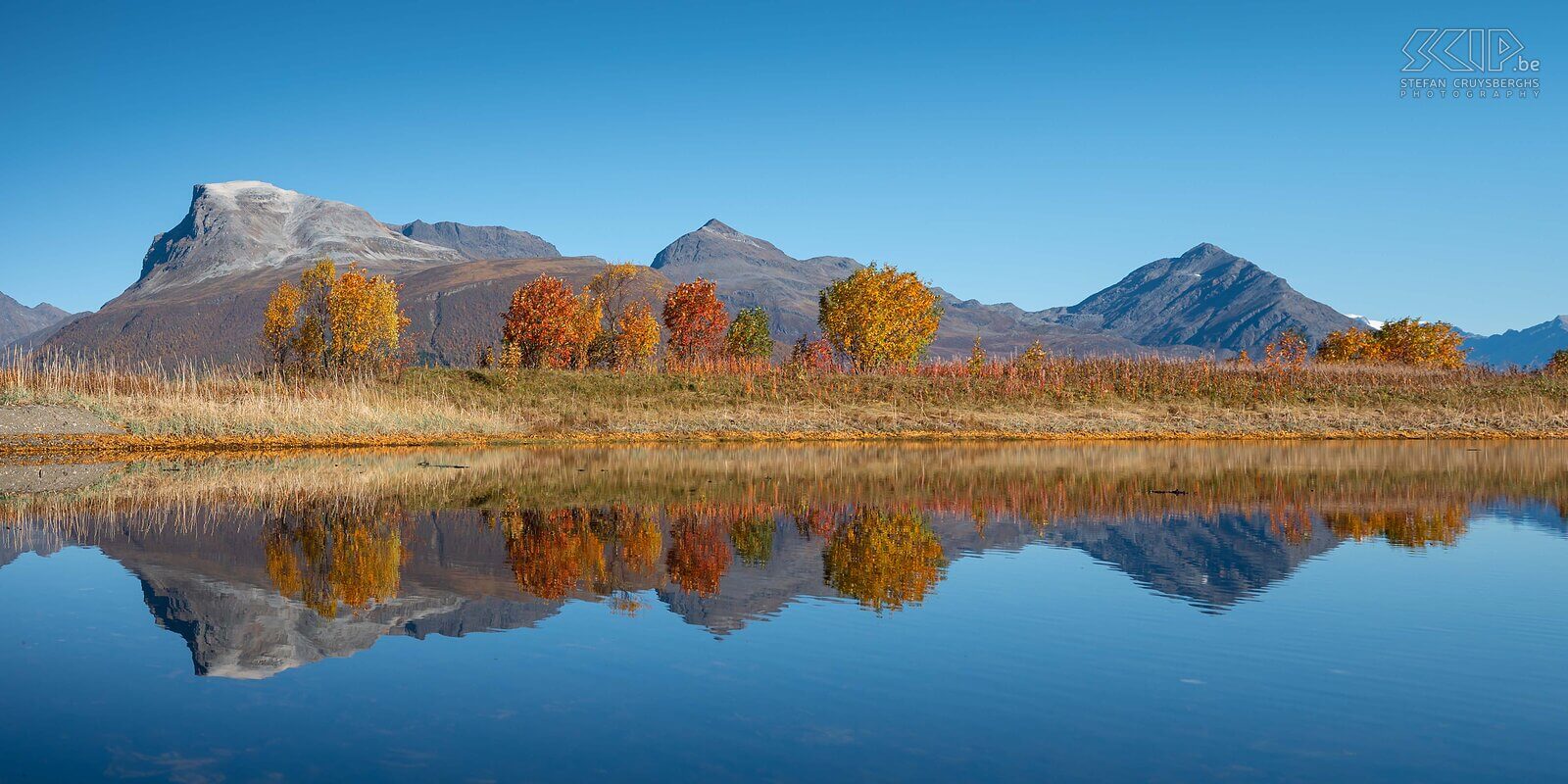 Norway - Storsteinnes A clear blue sky, trees with beautiful autumn colors and their reflection in a pond on the Balfsfjorden in the village of Storsteinnes Stefan Cruysberghs